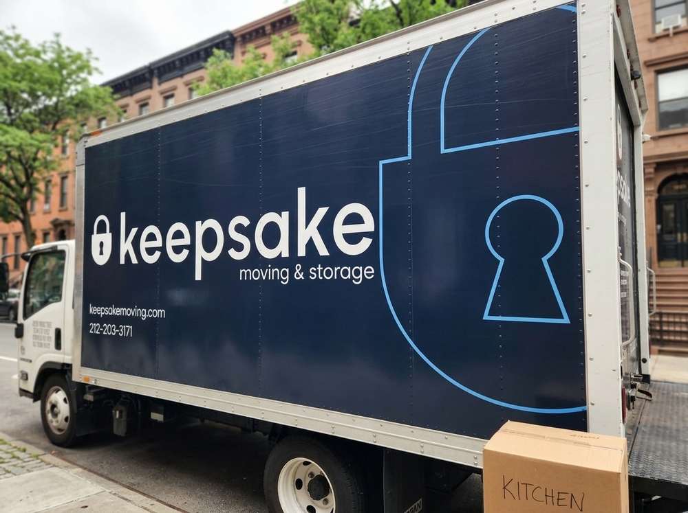 A Keepsake box truck on a New York street, its navy side panel carrying the padlock mark.